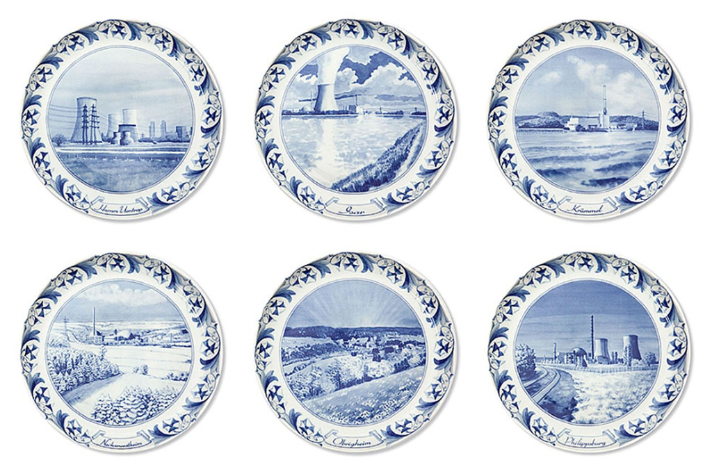 Six vintage-style ceramic plates depicting nostalgic-type illustrations of nuclear power plants
